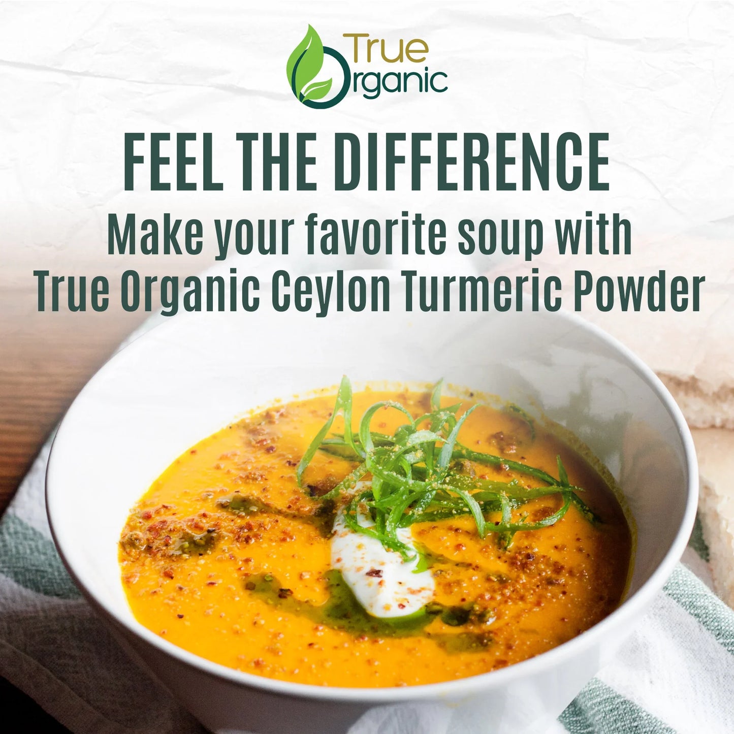 Creamy turmeric soup in a white bowl garnished with green herbs and a dollop of cream