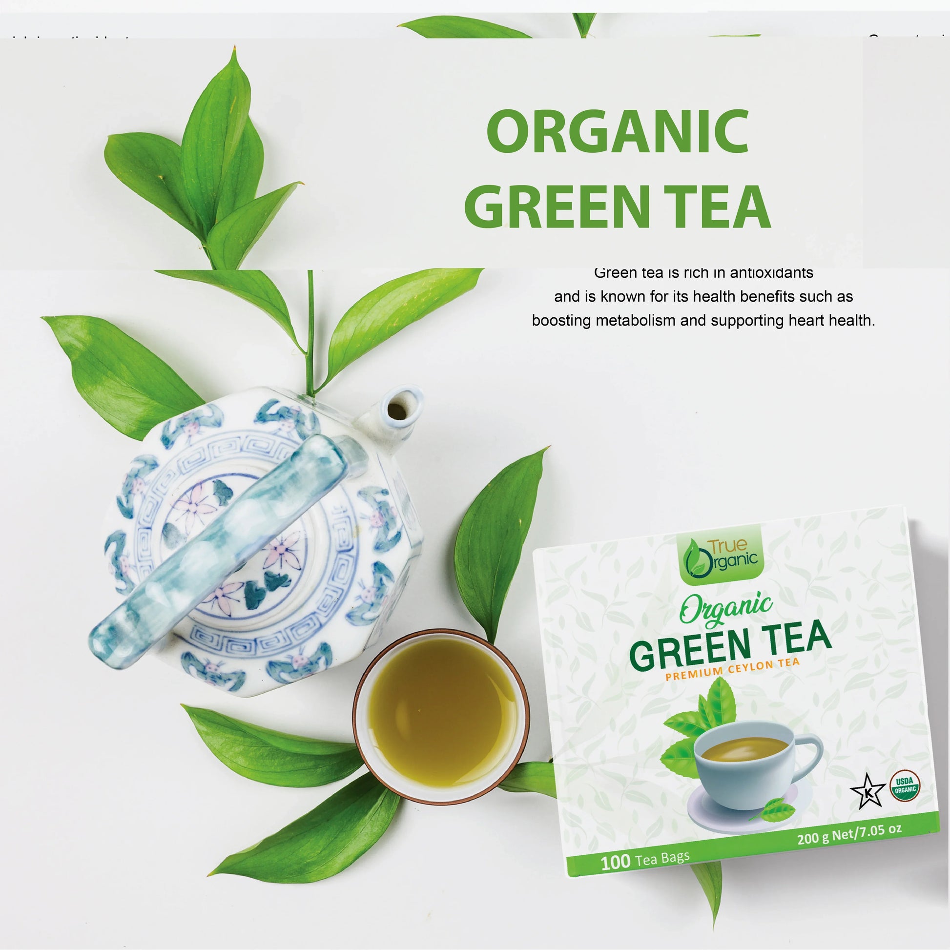 Organic green tea packaging, ceramic teapot, cup of green tea, and fresh green tea leaves on white background