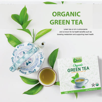 Organic green tea packaging, ceramic teapot, cup of green tea, and fresh green tea leaves on white background