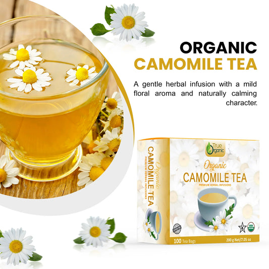 Organic camomile tea packaging and a glass cup with chamomile flowers floating on light herbal infusion