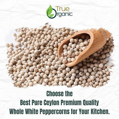True Organic logo with wooden scoop filled with whole white peppercorns scattered on white background