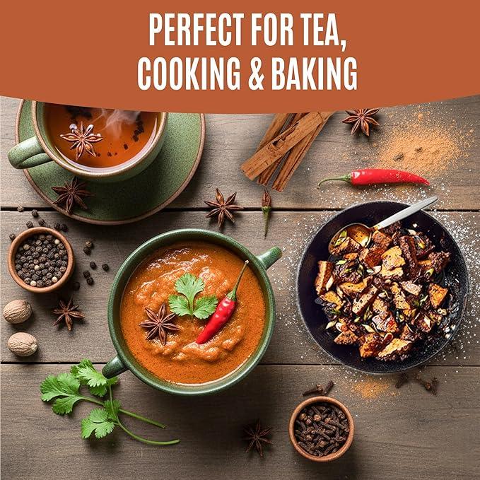 Spiced tea, curry soup, and roasted dish with chili, cinnamon, peppercorns, and herbs on wooden table