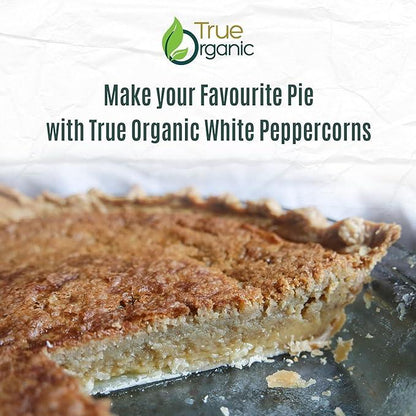 Close-up of a homemade pie with a golden crust in a glass baking dish, promoting True Organic white peppercorns