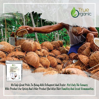 Farmer harvesting coconuts amidst a pile of cracked coconut shells in a tropical farm setting
