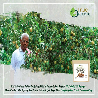Elderly farmer harvesting nutmeg from lush green tree with True Organic Nutmeg Whole packaging