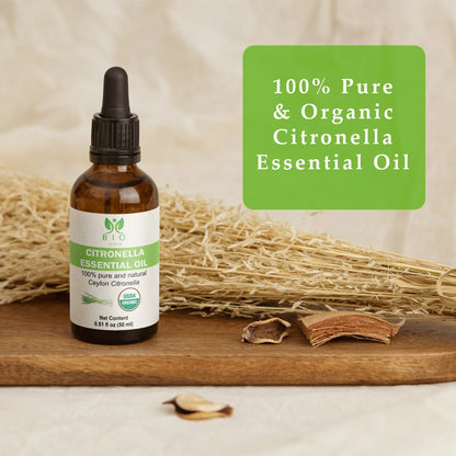Amber bottle of 100% pure organic citronella essential oil on wooden tray with dried plants