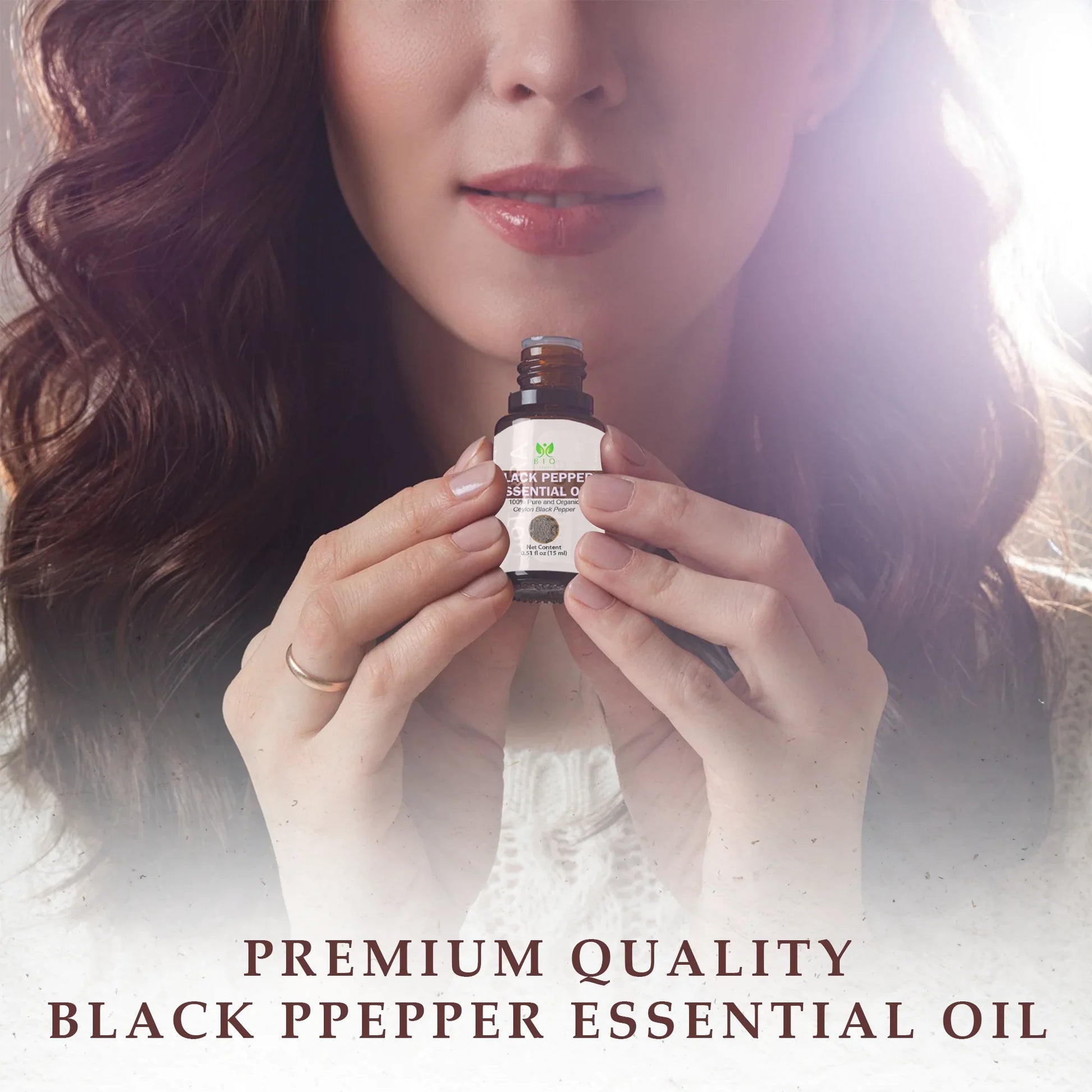 Woman holding a bottle of premium quality black pepper essential oil with natural light