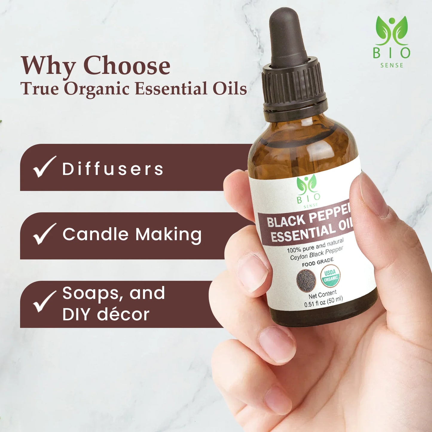 Hand holding 50ml bottle of Bio Sense Black Pepper essential oil with uses listed for diffusers, candle making, soaps