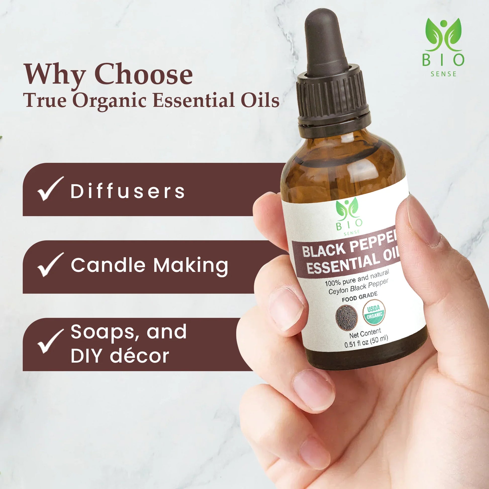 Hand holding 50ml bottle of Bio Sense Black Pepper essential oil with uses listed for diffusers, candle making, soaps