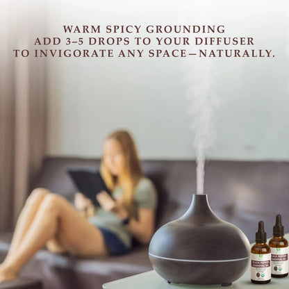 Dark wood essential oil diffuser emitting vapor with black pepper essential oil bottles on glass table in living room