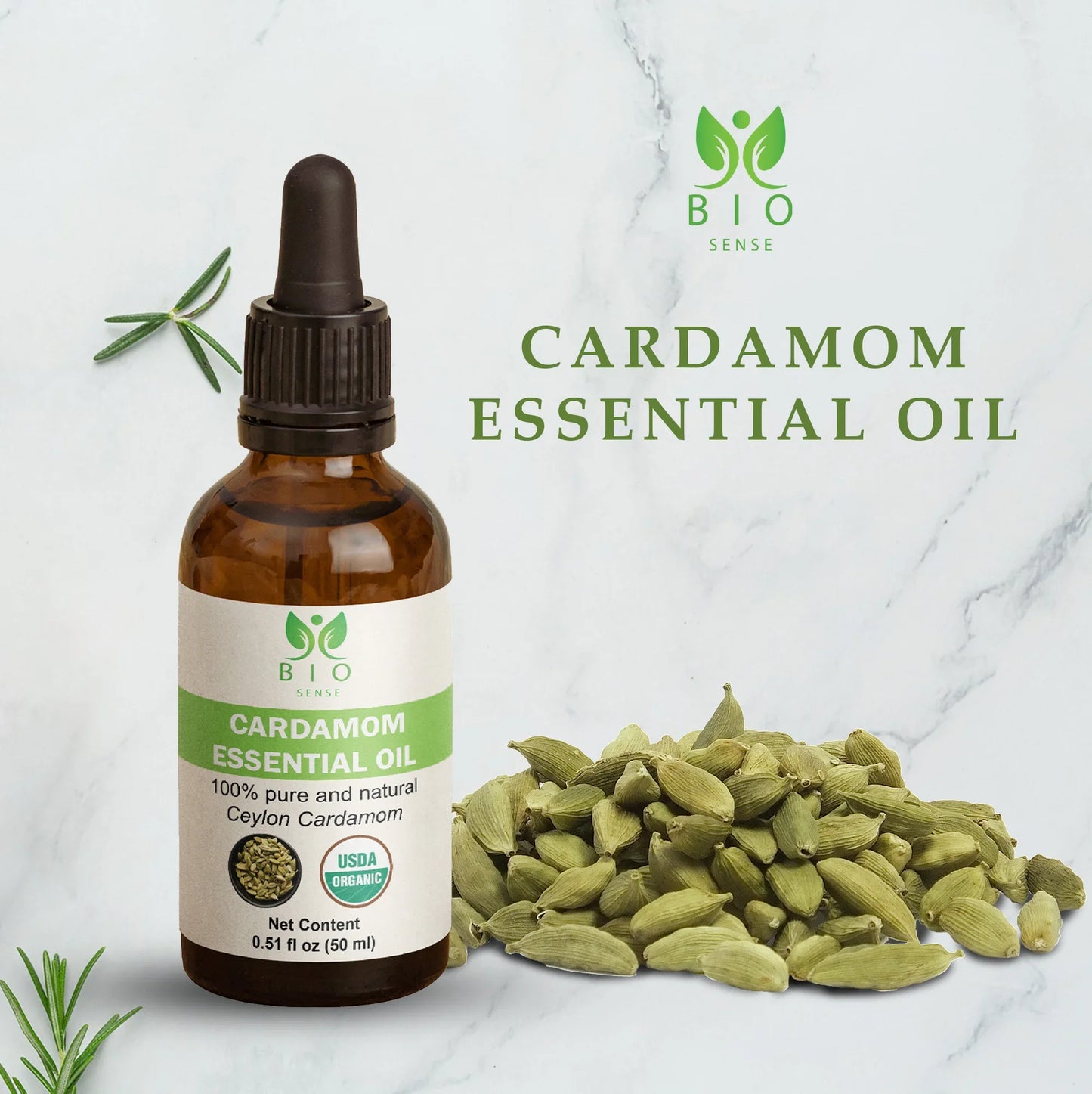 Bio Sense cardamom essential oil bottle next to green cardamom pods on marble background