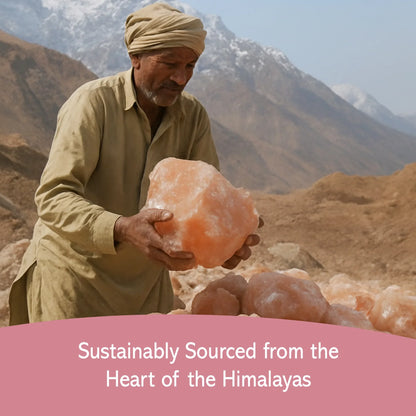Man holding large Himalayan pink salt crystal with mountain range in background