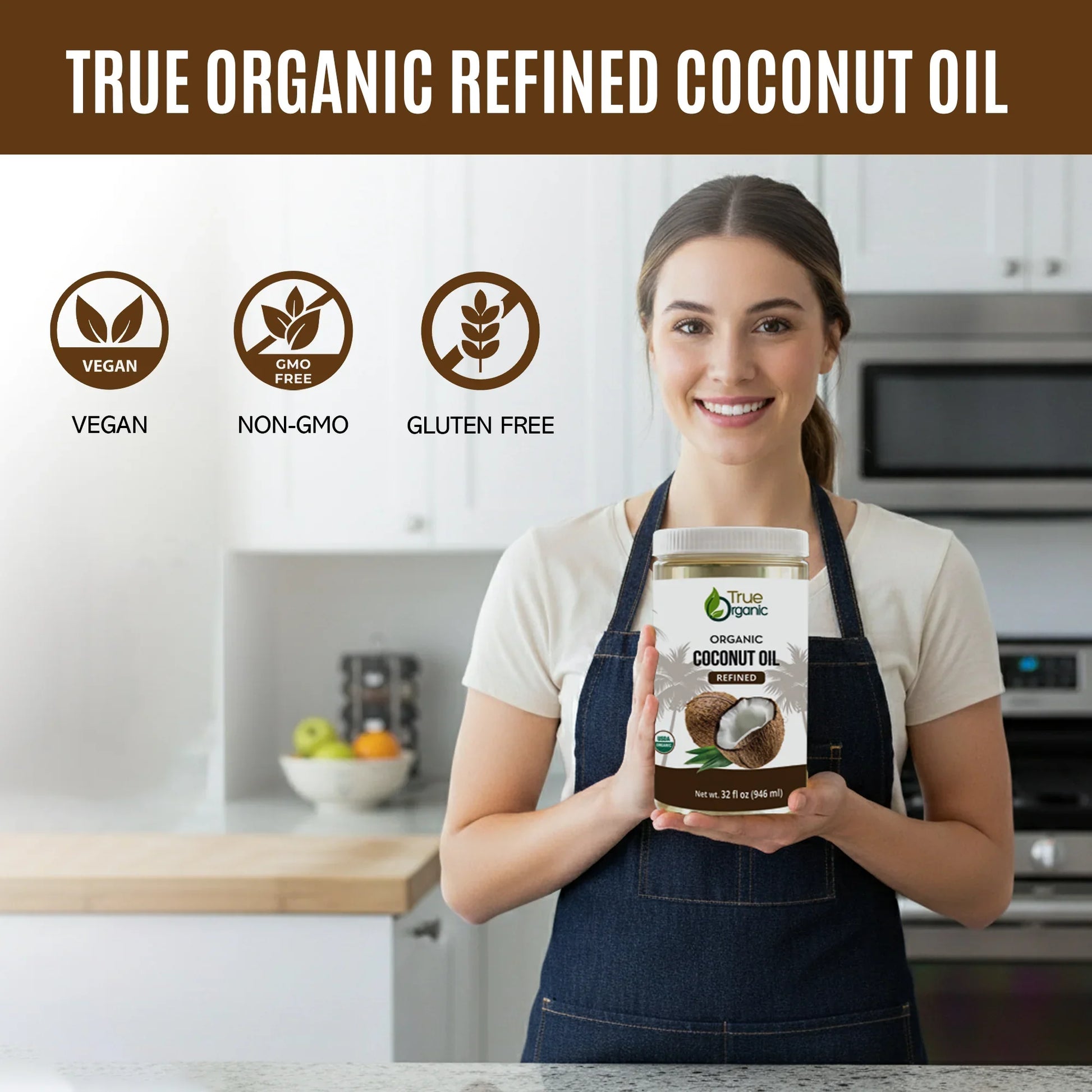 Smiling woman in kitchen holding 32 fl oz jar of True Organic refined coconut oil, vegan gluten-free non-GMO