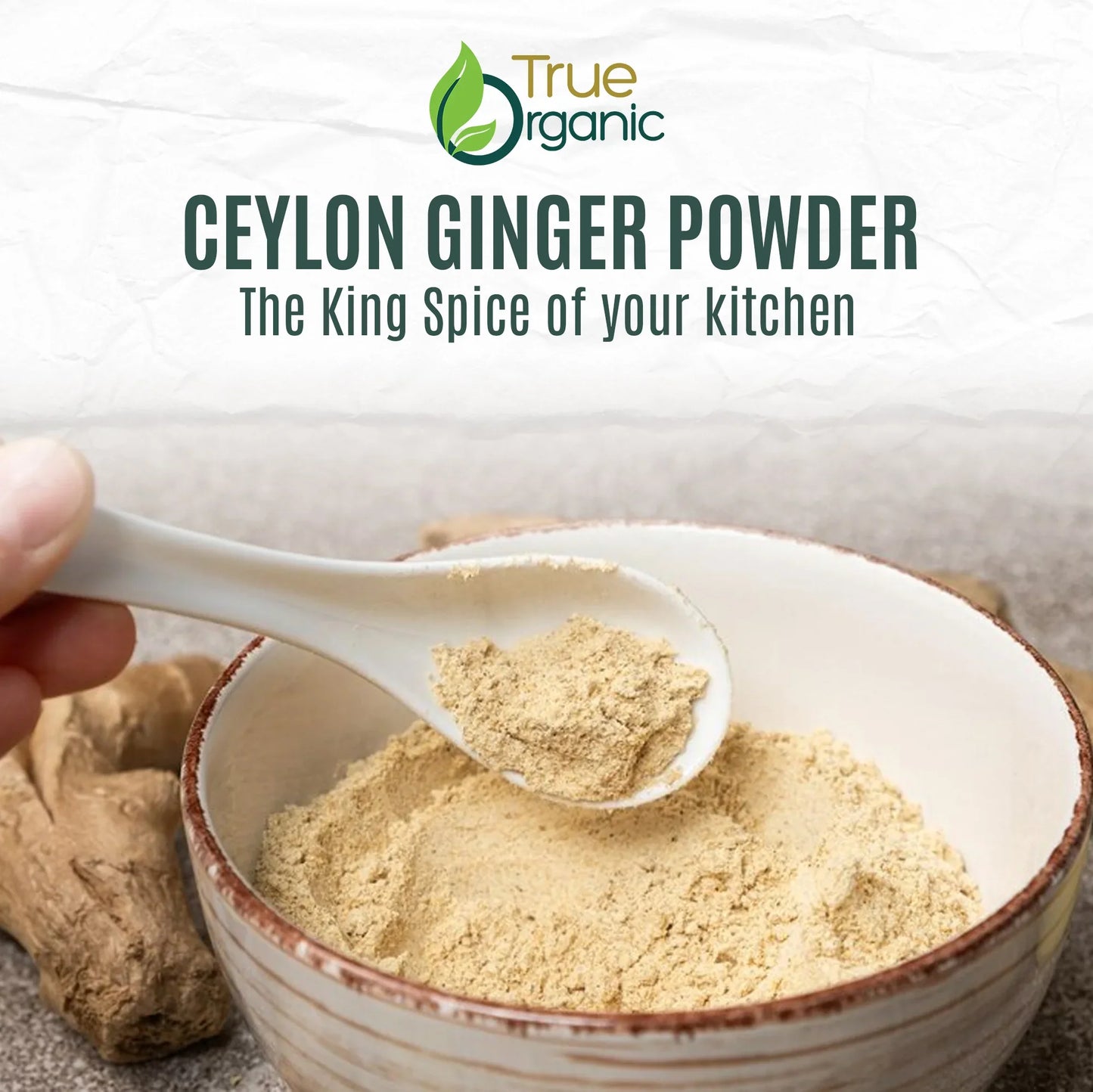 True Organic Ceylon ginger powder in a ceramic bowl with a spoon and ginger root on a textured surface